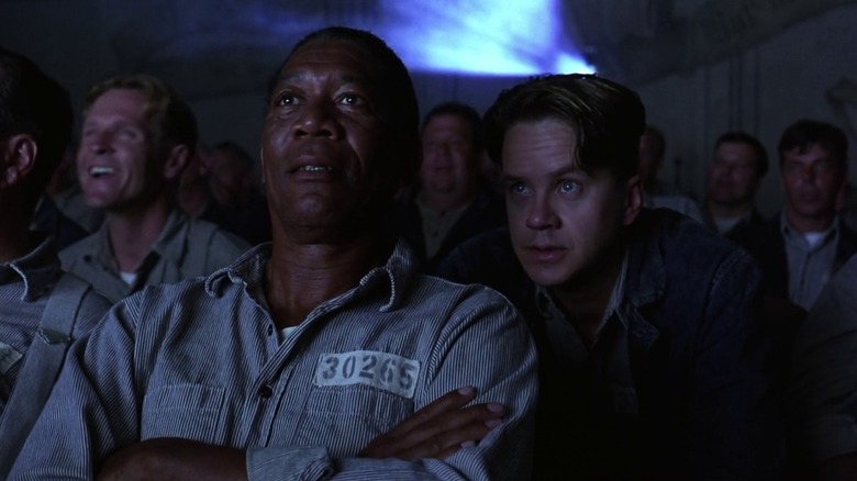 Red (Morgan Freeman) and Andy (Tim Robbins) watch a movie in The Shawshank Redemption