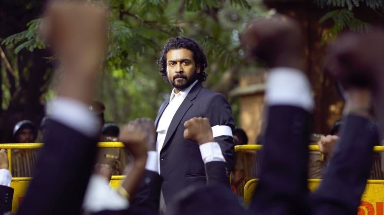 Suriya as K. Chandru observes a crowd of supporters in Jai Bhim.