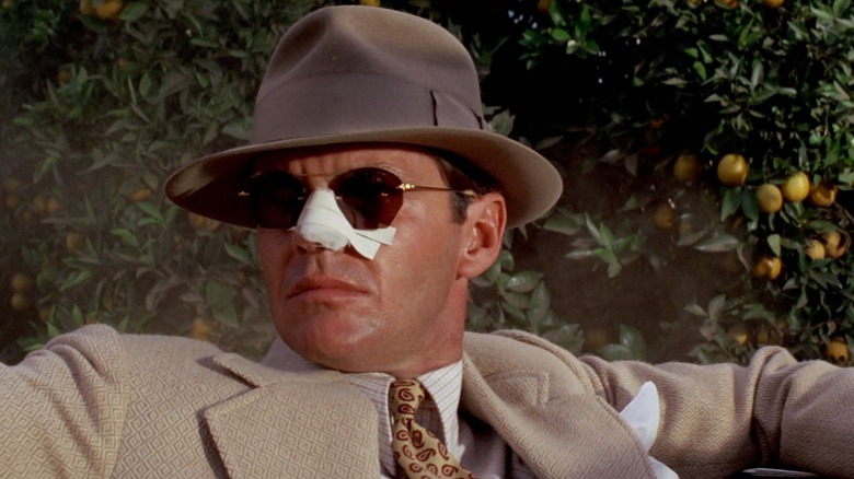 Jake Gittes (Jack Nicholson) sits with a bandaged nose in Chinatown (1974)