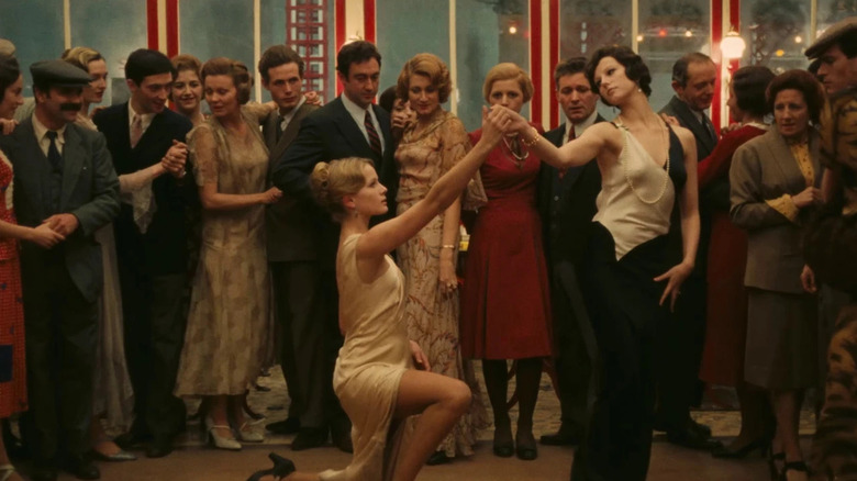 Anna Quadri (Dominique Sanda) kneels while holding the hand of Giulia (Stefania Sandrelli) in The Conformist (1970)