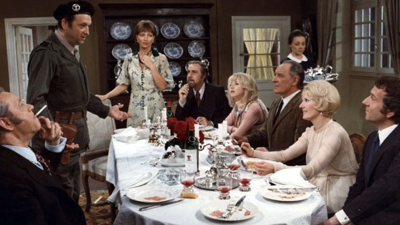 The ensemble of The Discreet Charm of the Bourgeoisie converses at dinner