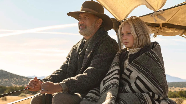 Tom Hanks as Captain Kidd and Helena Zengel as Johanna, riding in a wagon in News of the World.