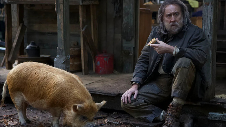 Nicolas Cage, sitting on the ground next to his pig in Pig.