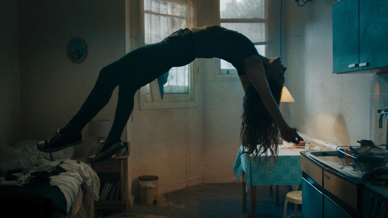Morfydd Clark as Katie, rising in the air with her back arched in Saint Maud.