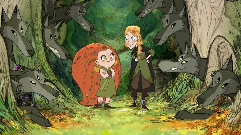 Mebh and Robyn, smiling and surrounded by wolves in the forest in Wolfwalkers.