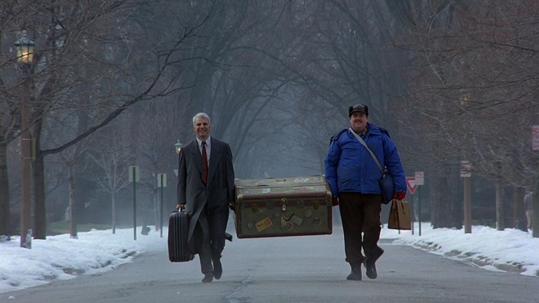 Neal Page (Steve Martin) and Del Griffith (John Candy) carrying a case in Planes, Trains and Automobiles