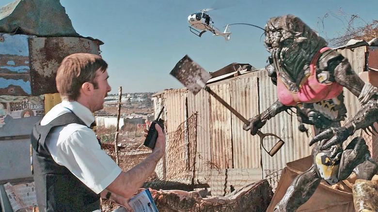 Sharlto Copley as Wikus, standing in front of a prawn in District 9