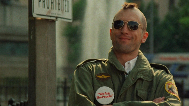 Robert De Niro as Travis Bickle standing in near a sign in Taxi Driver
