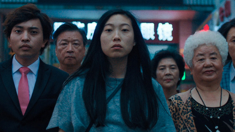 Awkwafina as Billi Wang standing with her family in The Farewell