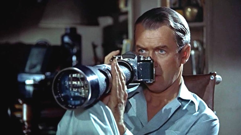 James Steward as L.B. "Jeff" Jefferies in Rear Window, looking out of his window through his long-lens camera.