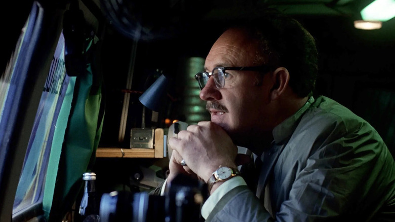 Gene Hackman as Harry Caul in The Conversation, sitting at a table and looking at a screen.