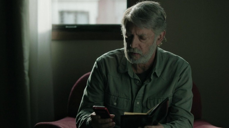 Manolo Solo as Miguel looking at his phone while holding a book in Close Your Eyes