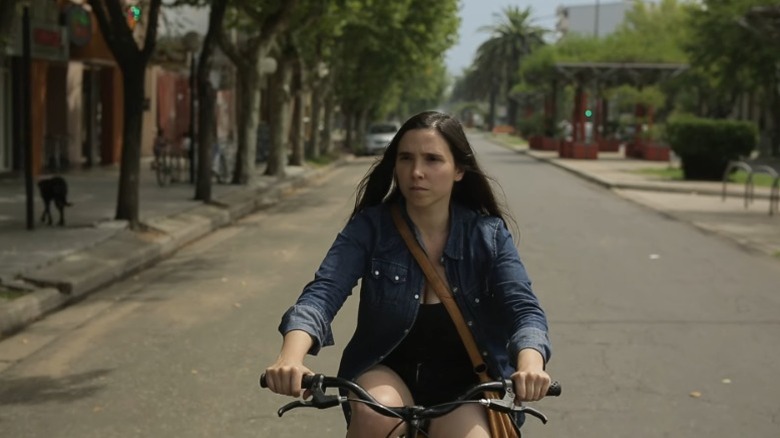 Laura Paredes as Laura riding a bicycle down the street in Trenque Lauquen