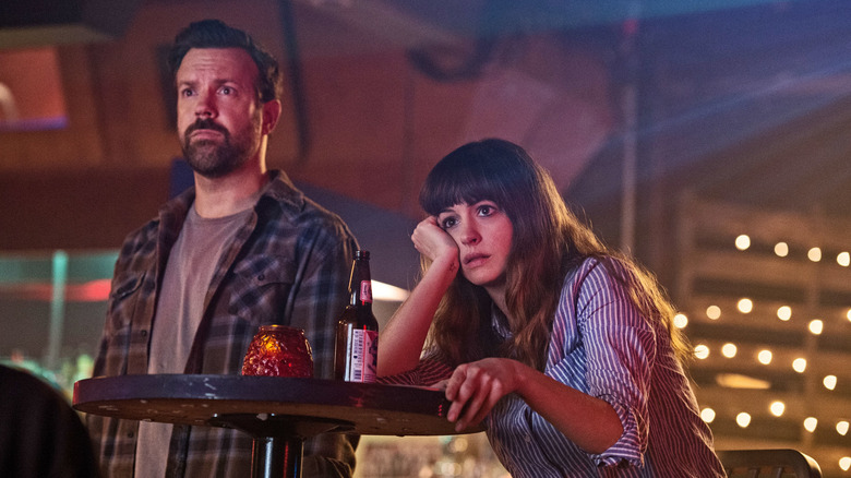 Jason Sudeikis as Oscar and Anne Hathaway as Gloria, watching the news in Colossal