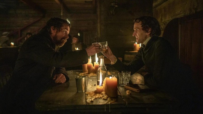 Christian Bale as Augustus and Harry Melling as Edgar, sharing a drink in The Pale Blue Eye