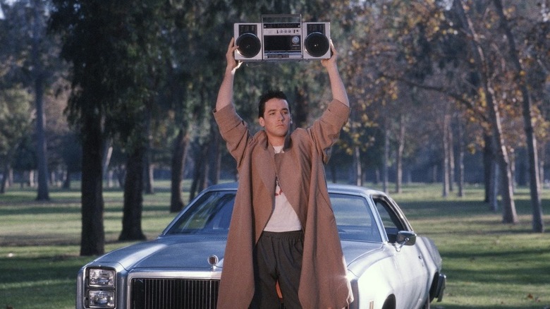 John Cusack as Lloyd holding a boombox over his head by a car in Say Anything