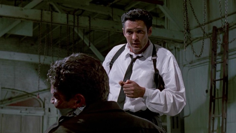 Michael Madsen as Mr. Blonde dancing in front of Kirk Baltz as Nash in Reservoir Dogs