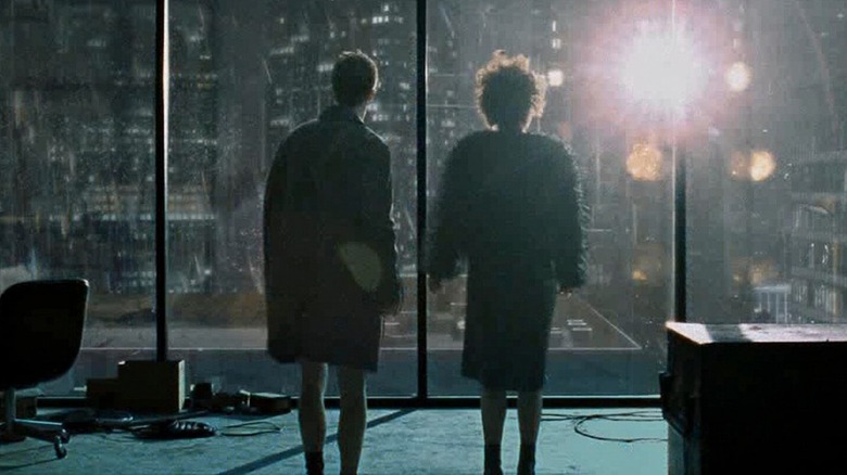 Ed Norton and Helena Bonham Carter as the narrator and Marla standing in front of a window at the end of Fight Club