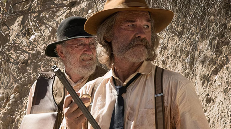 Kurt Russell as Sheriff Franklin Hunt and Richard Jenkins as Deputy Chicory in Bone Tomahawk, standing out with the sun bearing down both looking off in the same direction to the right.