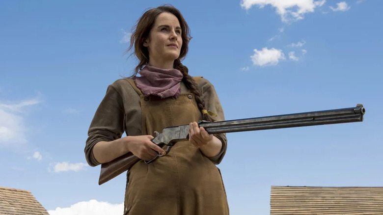 Alice Fletcher (Michelle Dockery) smiles holding a rifle in Godless