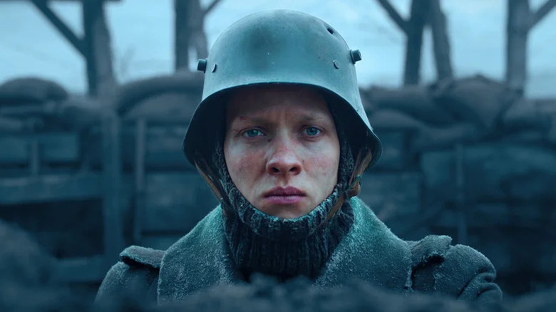 Felix Kammerer as Paul in military coat and helmet in All Quiet on the Western Front