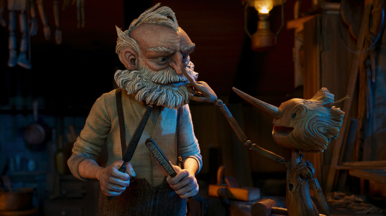 Stop-motion animated wooden Pinocchio putting finger on nose of old man Geppetto in Guillermo del Toro's Pinocchio