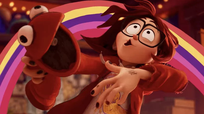 Katie, animated teen with dark nails and glasses, holding red puppet with rainbow behind her in The Mitchells vs. the Machines