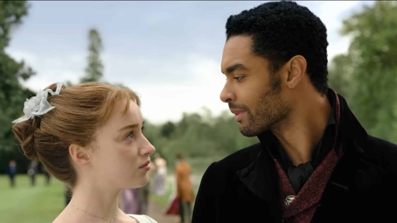 Phoebe Dynevor and Rege Jean-Page as Daphne and Simon looking at each other in Bridgerton