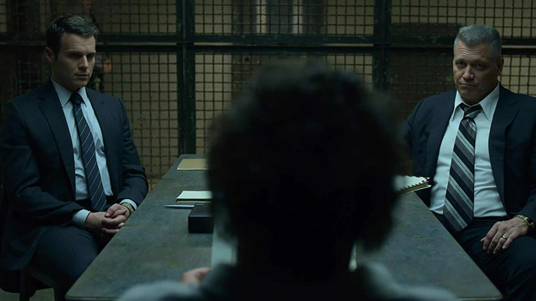Jonathan Groff and Holt McCallany as Holden and Bill sitting with a silhouetted figure in a cell in Mindhunter