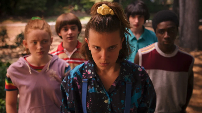 Eleven (Millie Bobby Brown) stands with Max (Sadie Sink), Will (Noah Schnapp), Lucas (Caleb McLaughlin), and Mike (Finn Wolfhard) in Stranger Things 3