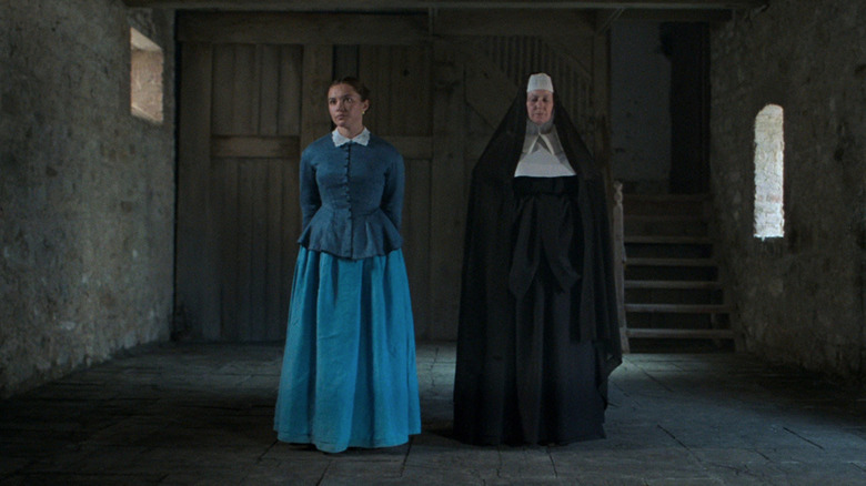 Lib (Florence Pugh) and Sister Michael (Josie Walker) standing in empty room in The Wonder