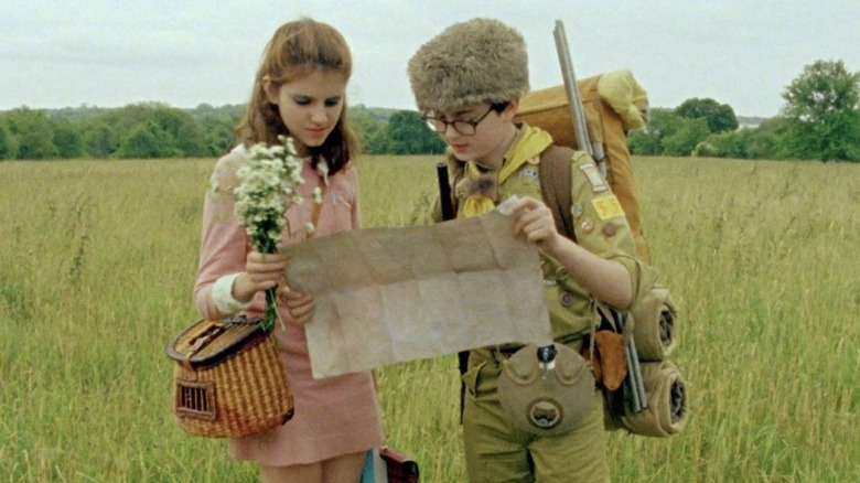 Kara Hayward as Suzy Bishop and Jared Gilman as Sam Shakusky looking at a map outside in Moonrise Kingdom