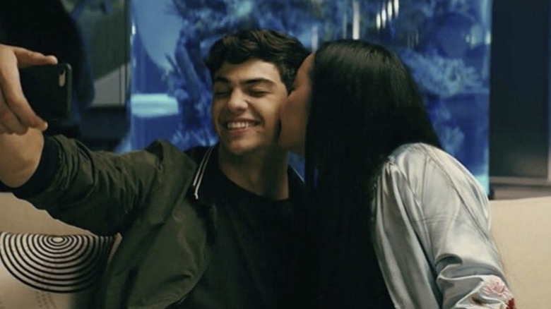 Noah Centineo as Peter Kavinsky being kissed by Lana Condor as Lara Jean Song-Covey as they take a photo in To All the Boys I've Loved Before