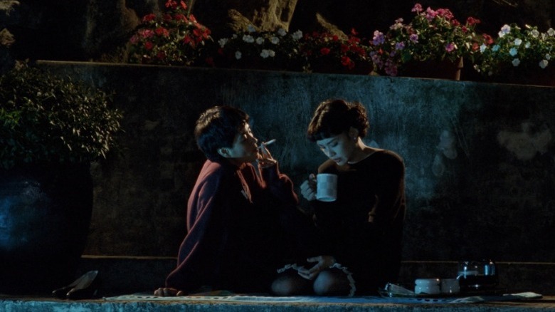 Suk Kwan Ni as Molly sitting next to a pool and smoking a cigarette while Chen Shiang-chyi as Qiqi drinks from a cup beside her in A Confucian Confusion