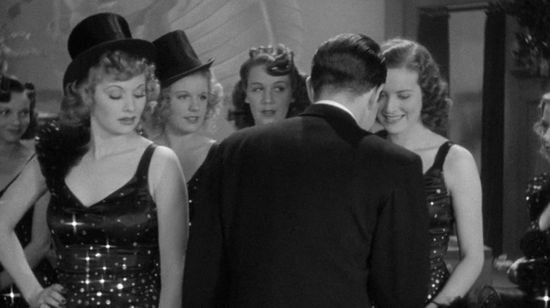 Lucille Ball as Bubbles and other chorus girls glaring at Louis Hayward as Jimmy Harris holding the hand of Maureen O'Hara as Judy O'Brien in Dance, Girl, Dance