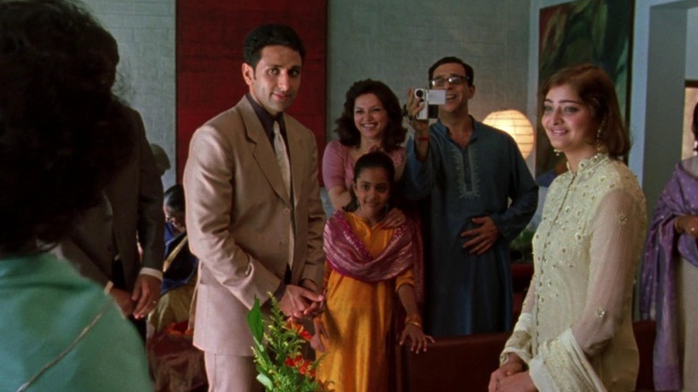 Wedding guests surrounding Parvin Dabas as Hermant Rai and Vasundhara Das as Aditi Verma in Monsoon Wedding
