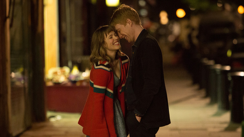 Rachel McAdams as Mary laughs with Domhnall Gleeson as Tim on the sidewalk at night in About Time