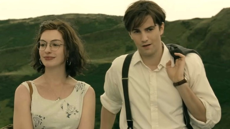 Anne Hathaway as Emma stands in front of hills next to Jim Sturgess as Dexter in One Day