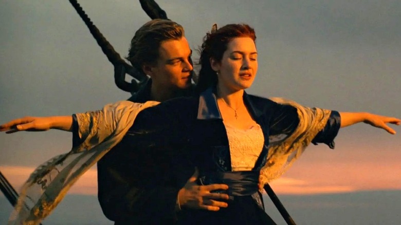 Leonardo DiCaprio as Jack Dawson holds Kate Winslet as Rose DeWitt Bukater as she holds her arms out in Titanic