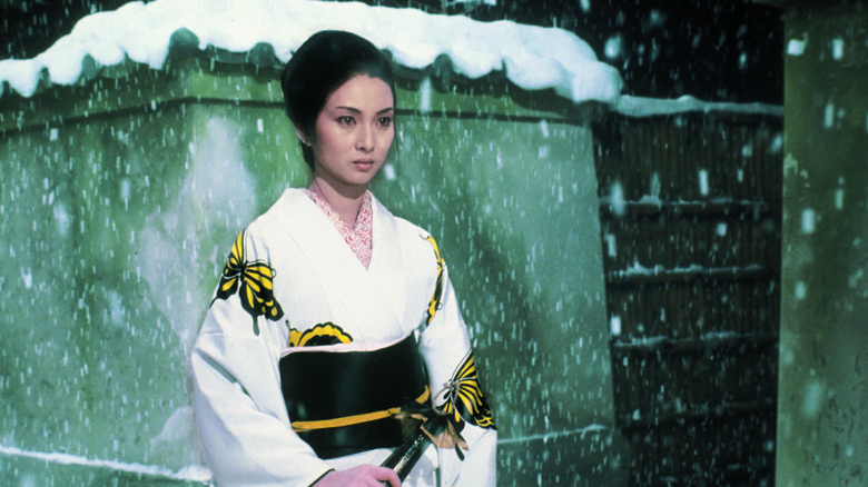 Yuki Kashima (Meiko Kaji) walks through the snow holding her sword in Lady Snowblood