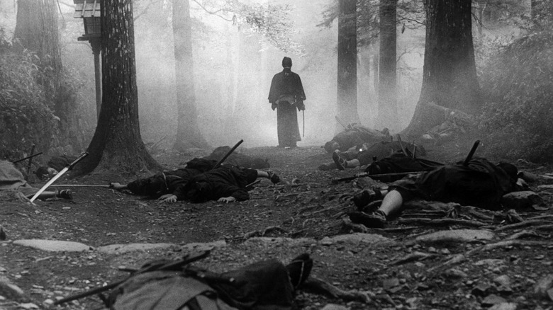 Ryunosuke Tsukue (Tatsuya Nakadai) walks through a misty forest past slain swordsmen in The Sword of Doom