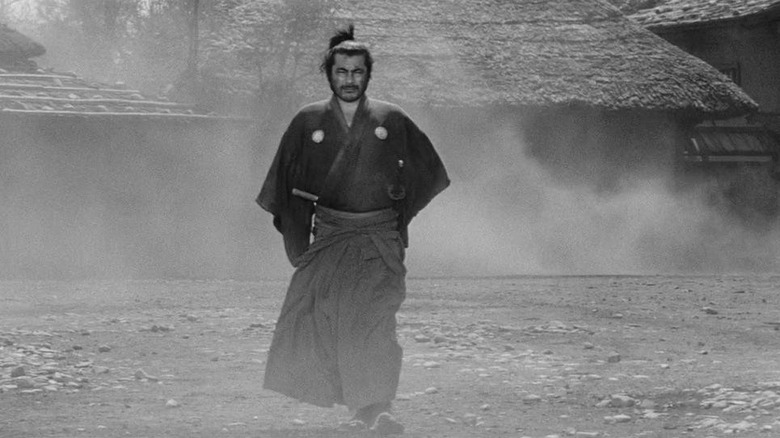 Kuwabatake Sanjuro (Toshiro Mifune) walks through a smoky village in Yojimbo