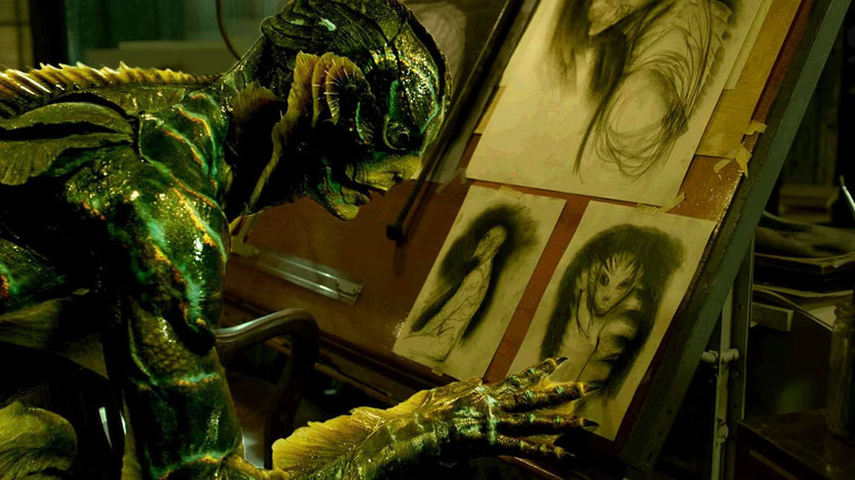 Doug Jones as the Amphibian Man, looking at drawings of himself in The Shape of Water.