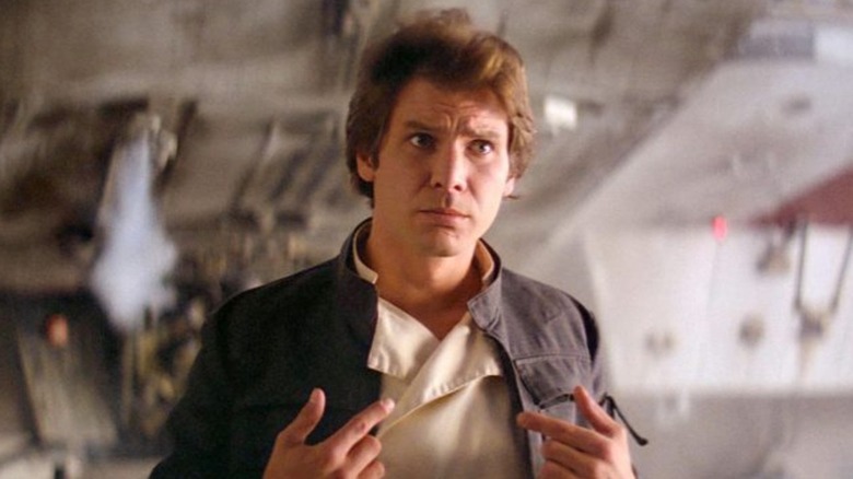 Harrison Ford as Han Solo, pointing to himself under the Falcon in Star Wars.