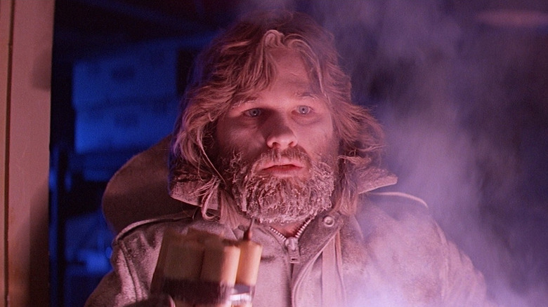 Kurt Russell as R. J. MacReady, lighting a flare in The Thing.