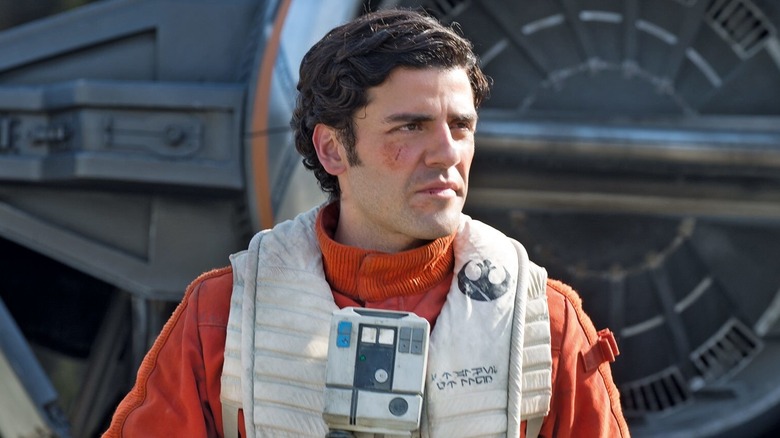 Oscar Isaac as Poe Dameron, looking to the side in Star Wars: The Force Awakens.