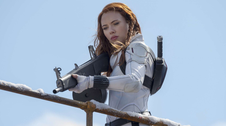 Scarlett Johansson as Natasha Romanoff, aiming a gun in Black Widow.