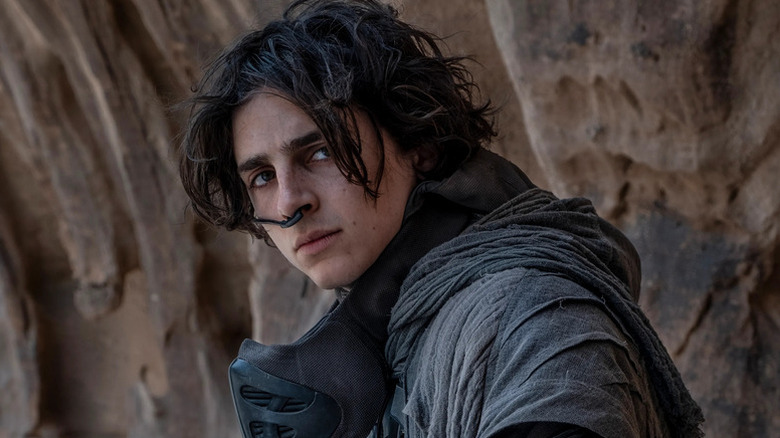 Timothée Chalamet as Paul Atreides leering in the desert in Dune