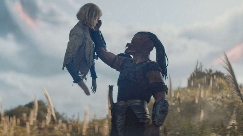 Dimitrius Schuster-Koloamatangi as Dek lifts the torso of Elle Fanning as android Thia in Predator: Badlands