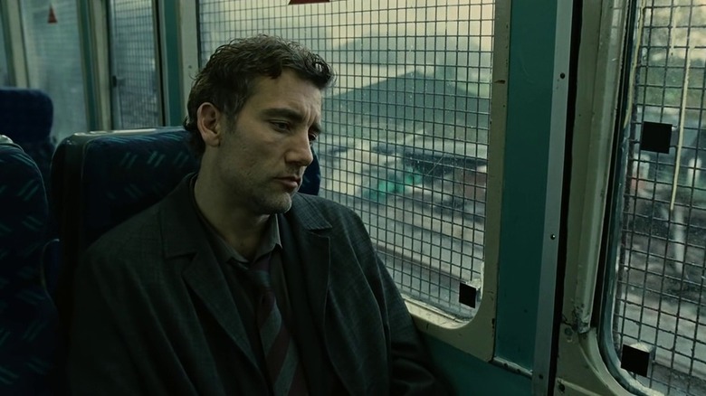 Clive Owen as Thelonius "Theo" Faron in Children of Men, sitting forlornly in a seat on a train.